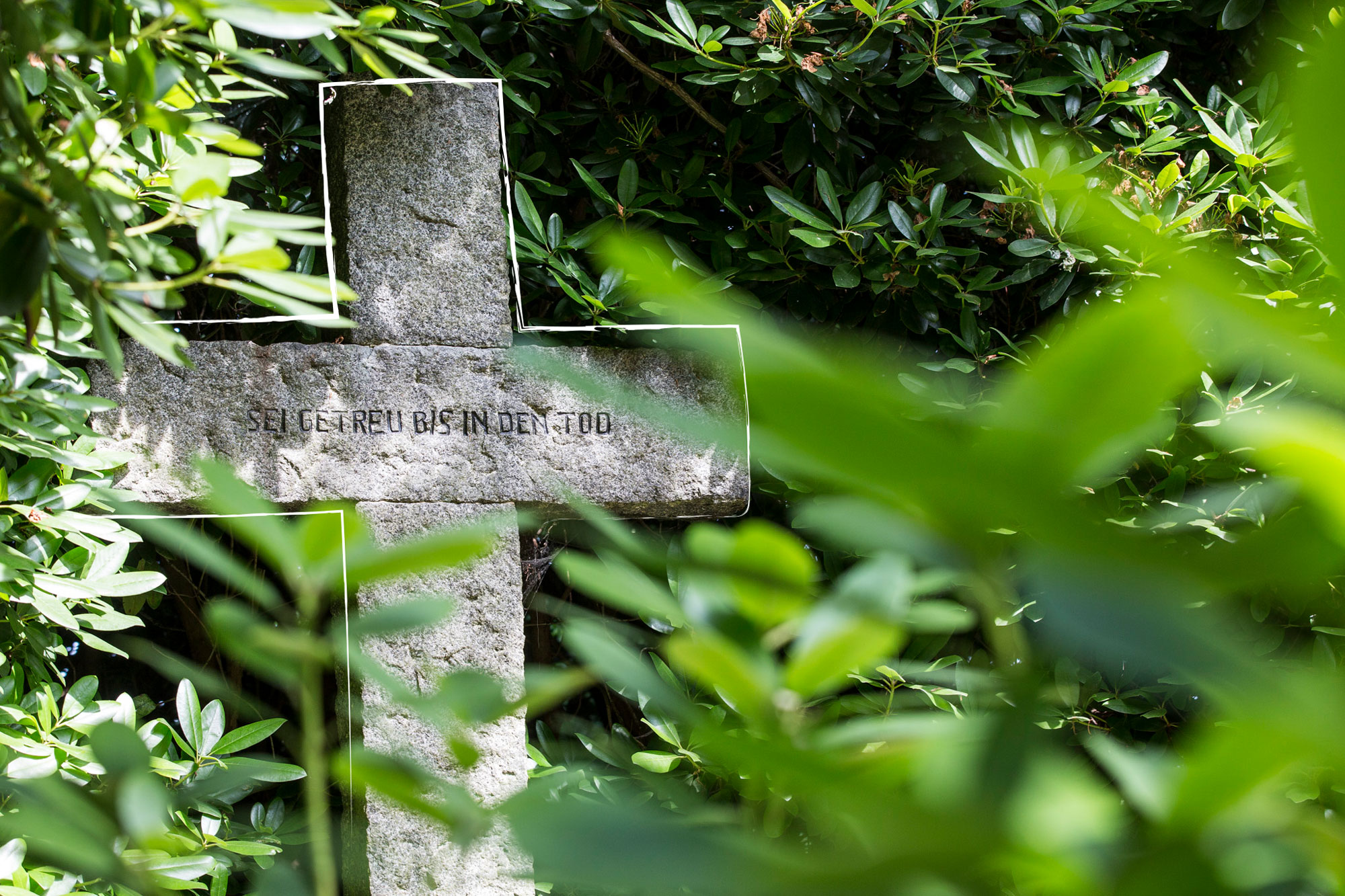 Steinernes Grabkreuz im Grün eines Karlsruher Friedhofs, Grabarten in Karlsruhe und Durlach